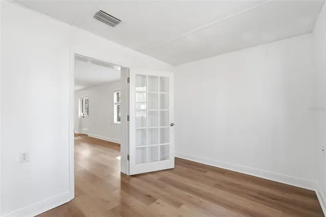 an empty room with wooden floor and entrance
