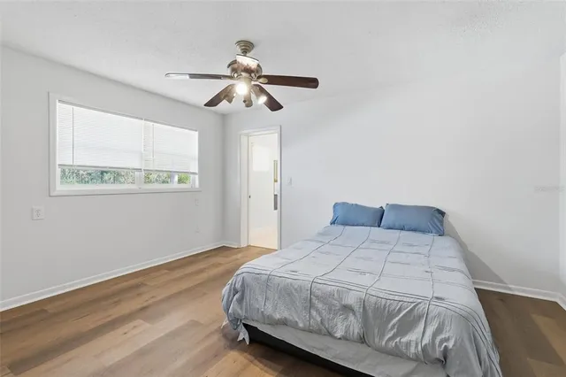 a bedroom with a bed and wooden floor