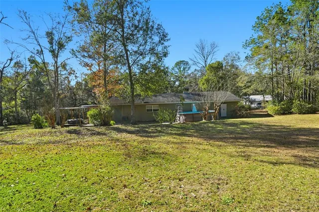 a view of a house with backyard and tree