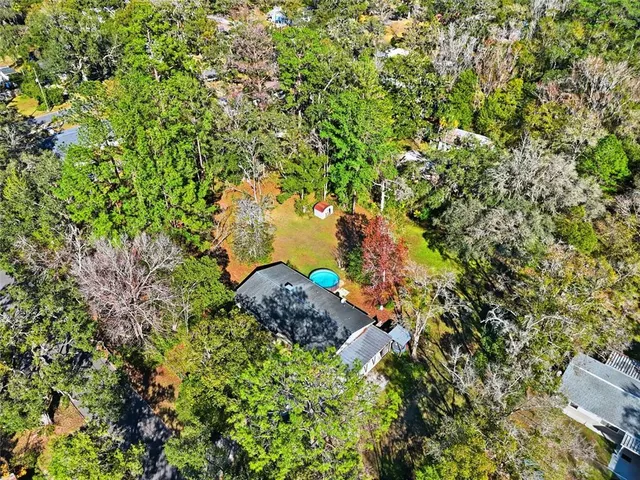 an aerial view of residential house with outdoor space and trees all around