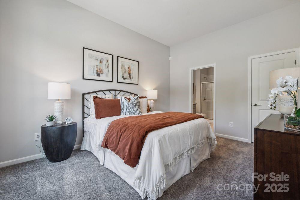 3132 Beacon Hts Road Indian Land, SC 29707 - Photo 16 of 34 a spacious bedroom with a bed and a lamp on dresser