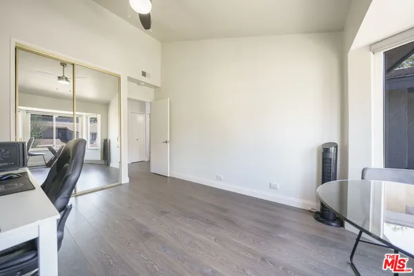 a view of a hallway with wooden floor and glass door