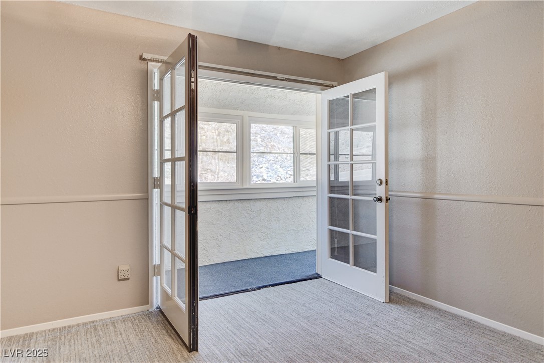845 Robinson Lane Boulder City, NV 89005 - Photo 43 of 66 Empty room with a textured wall, carpet, and french doors