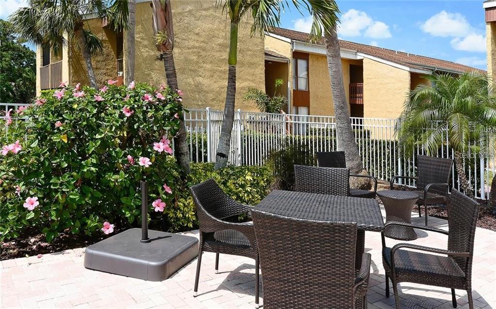 3469 Clark Road, Unit 267 Sarasota, FL 34231 - Photo 1 of 1 a view of a patio with couches table and chairs and potted plants