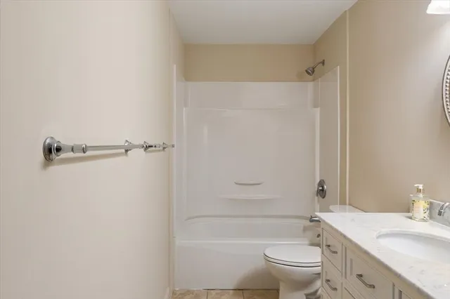 a bathroom with a granite countertop toilet a sink and a mirror