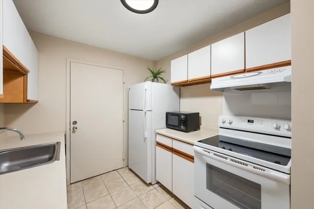 a kitchen with white cabinets and white appliances