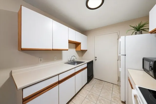 a kitchen with a sink cabinets and wooden floor