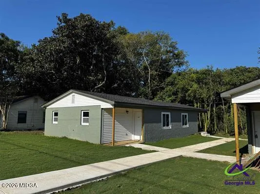 a front view of a house with a garden and yard