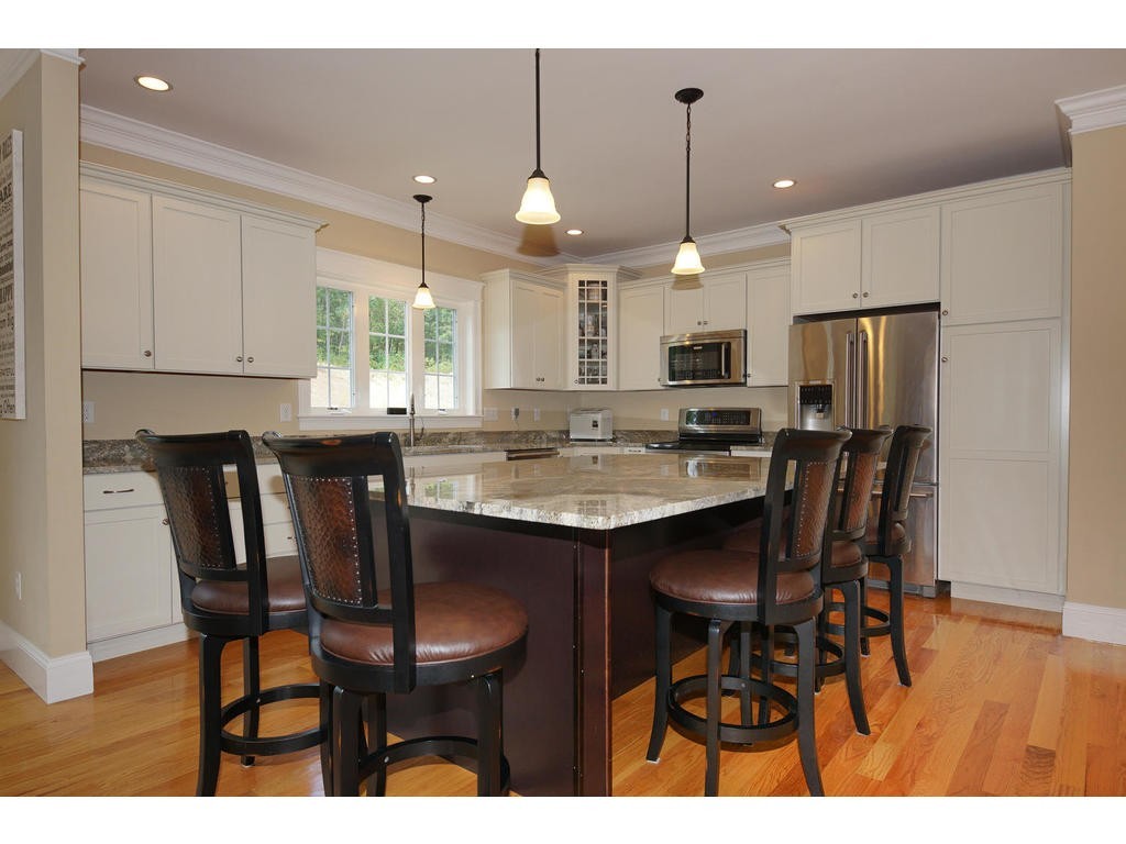 50 Fox Run Road Bolton, MA 01740 - Photo 3 of 20 a kitchen with kitchen island a dining table chairs and a refrigerator