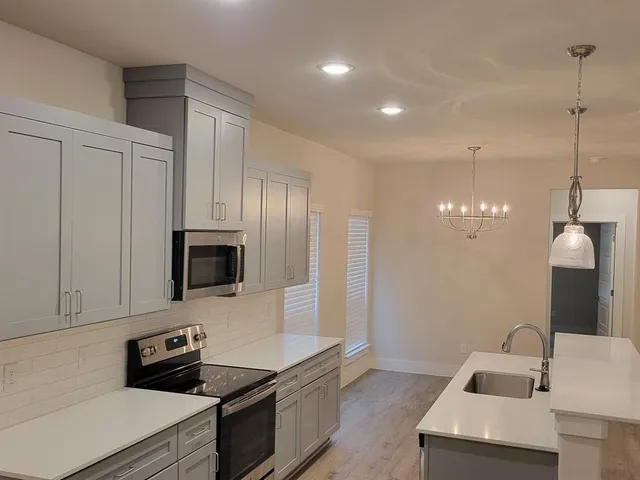 a kitchen that has a sink and a stove top oven