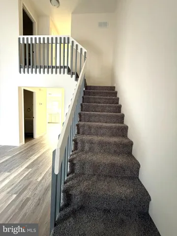 a view of a hallway with wooden floor and staircase