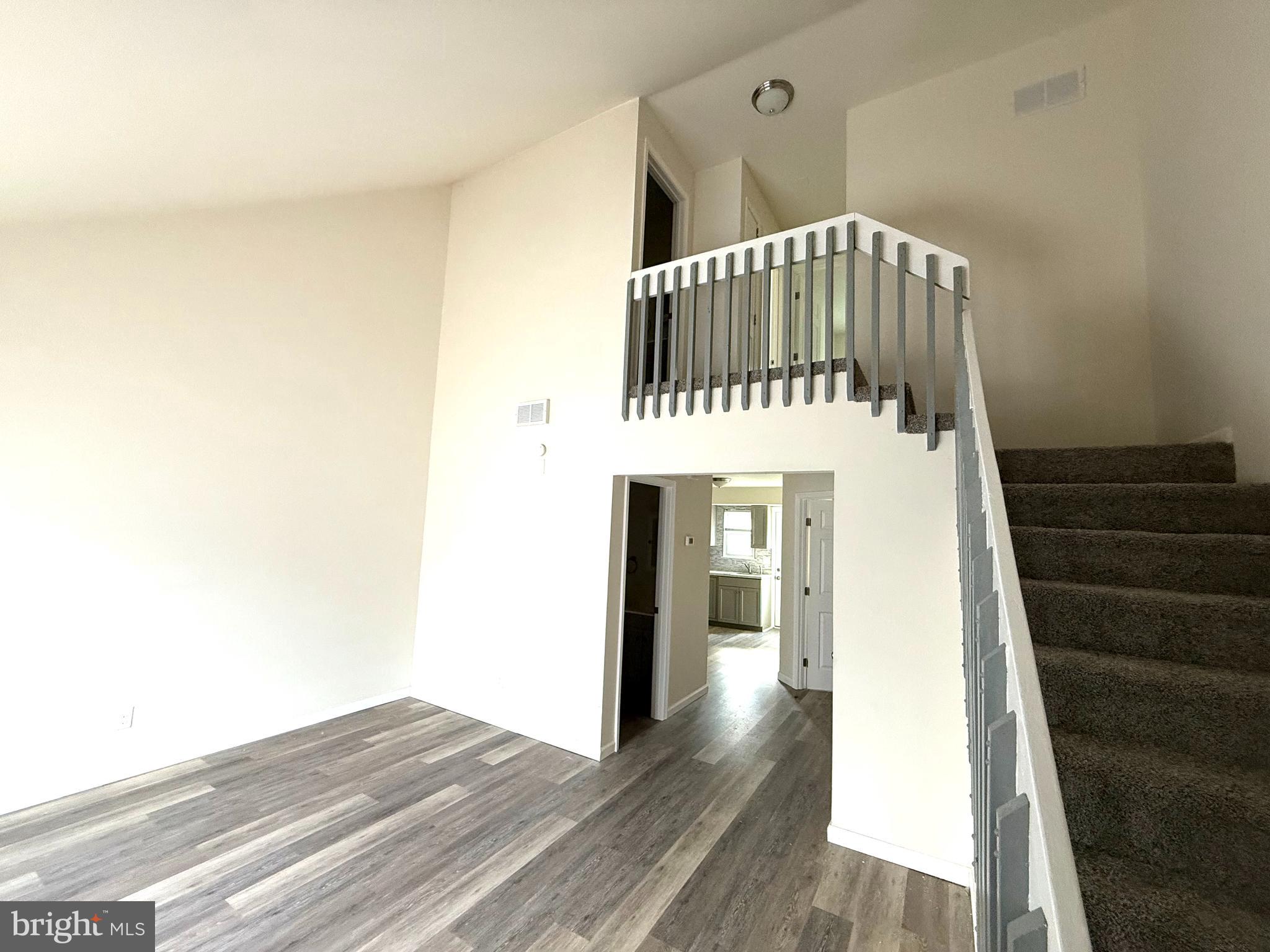 124 Spruance Road Dover, DE 19901 - Photo 4 of 17 a view of a hallway with wooden floor and staircase
