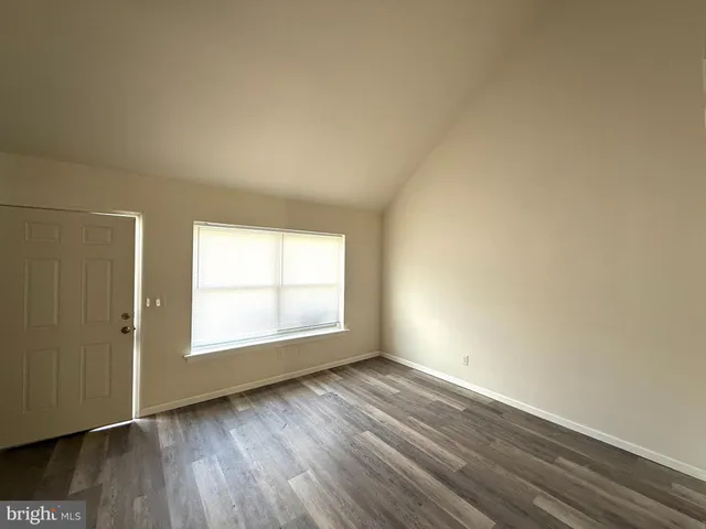an empty room with wooden floor and a window