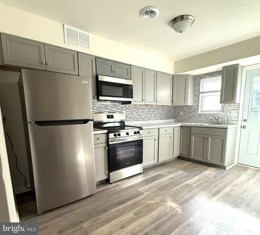 a kitchen with stainless steel appliances granite countertop a sink and cabinets