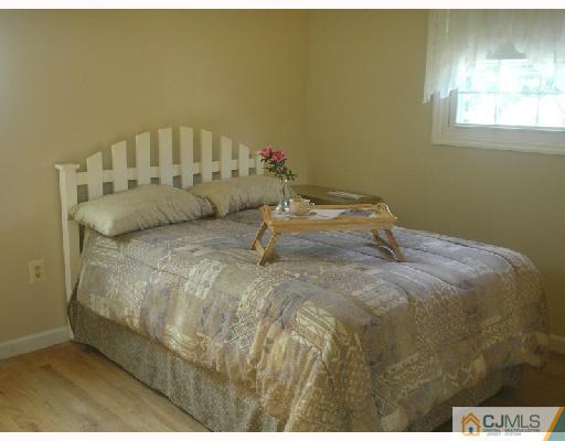 35 Warrenville Road Middlesex, NJ 08846 - Photo 10 of 10 a bed sitting in a bedroom next to a window