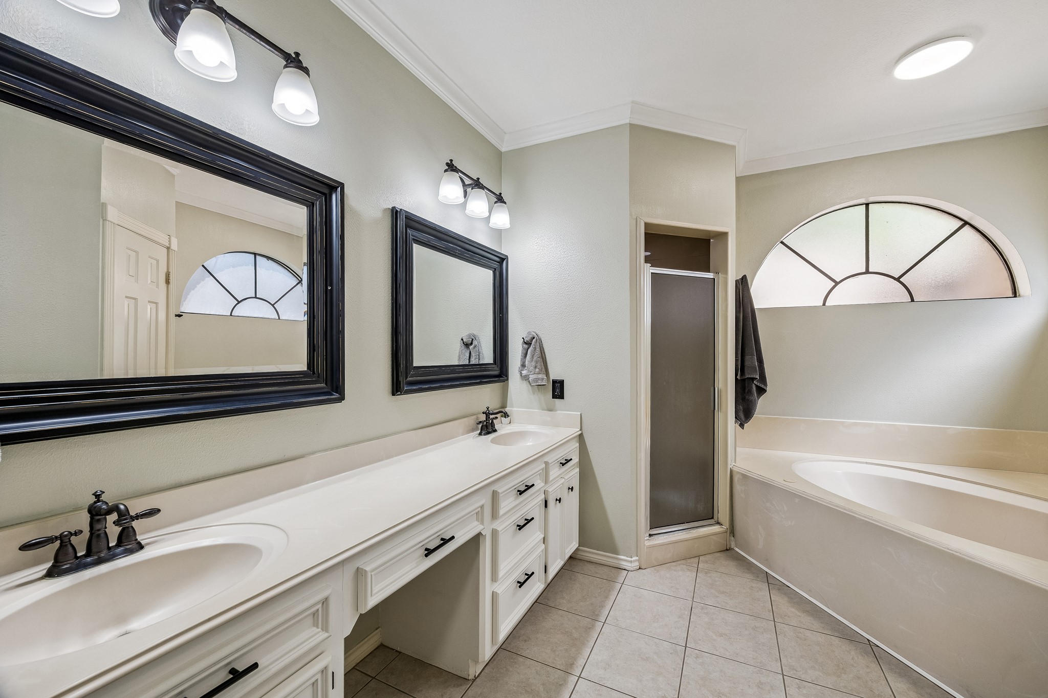 5823 Ashmere Lane Spring, TX 77379 - Photo 22 of 35 a bathroom with a sink a large mirror and a bathtub next to a window