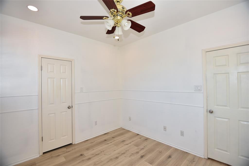 1503 Natural Bridge Lane Pflugerville, TX 78660 - Photo 3 of 20 an empty room with a ceiling fan and wooden floor