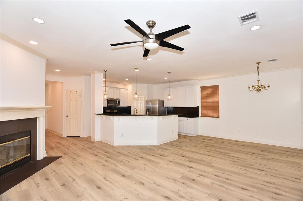 1503 Natural Bridge Lane Pflugerville, TX 78660 - Photo 8 of 20 a living room with stainless steel appliances kitchen island hardwood floor and a ceiling fan