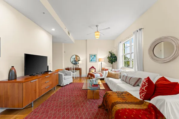 a living room with furniture a flat screen tv and a large window