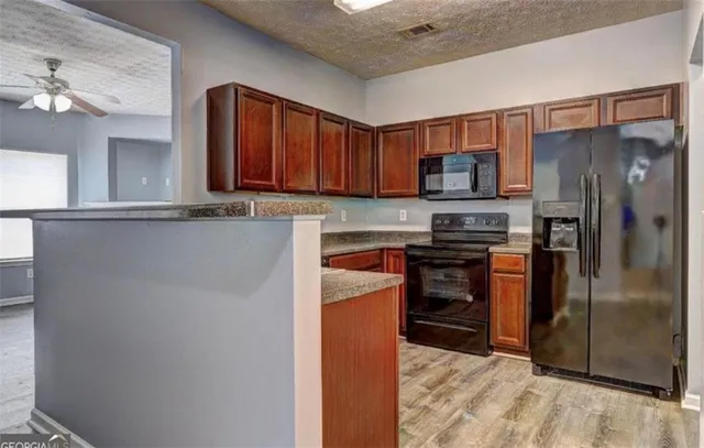 a kitchen with stainless steel appliances granite countertop a refrigerator and a stove top oven