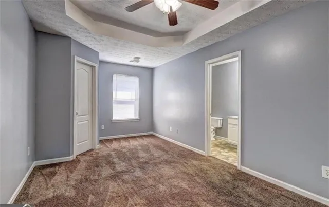 a view of an empty room and chandelier fan