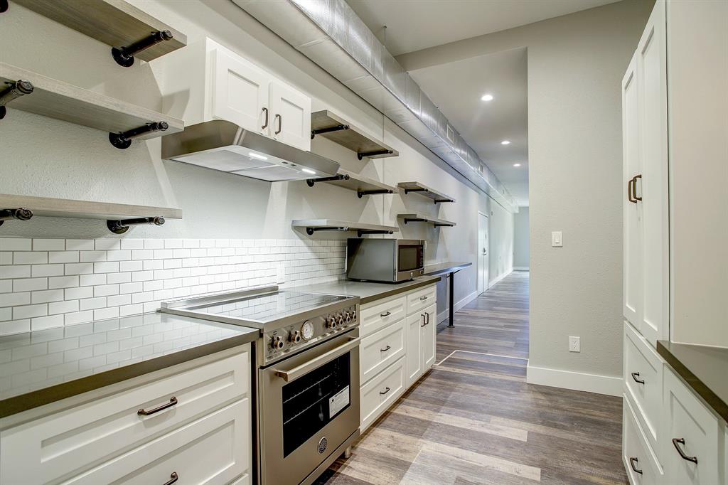 a kitchen with stainless steel appliances a stove and wooden floor