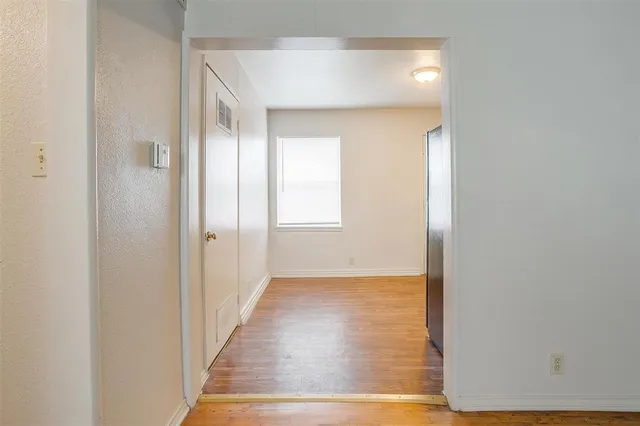 a view of a hallway with wooden floor