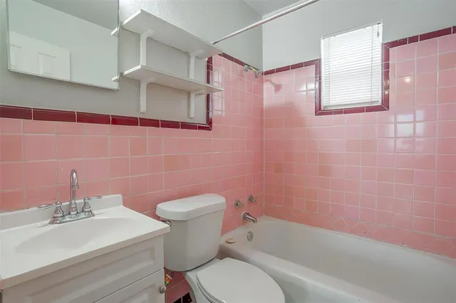 a white toilet sitting next to a bathroom sink and a shower