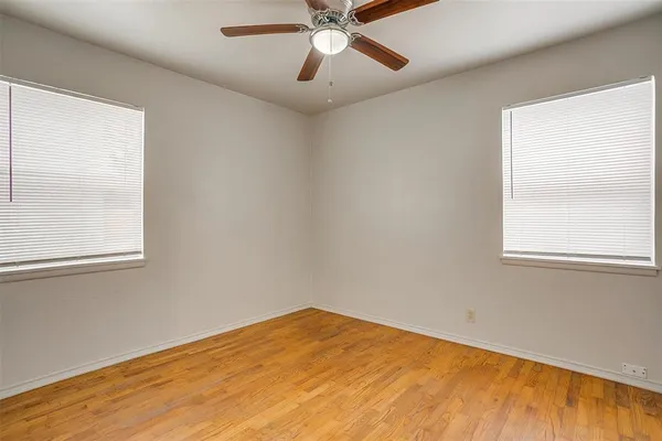 a view of empty room with window and ceiling fan