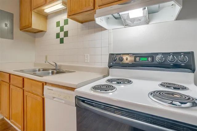 a kitchen with a stove and a sink with cabinets