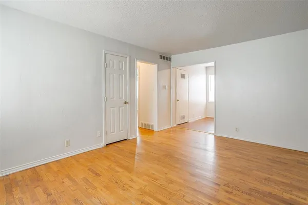 a view of an empty room with wooden floor