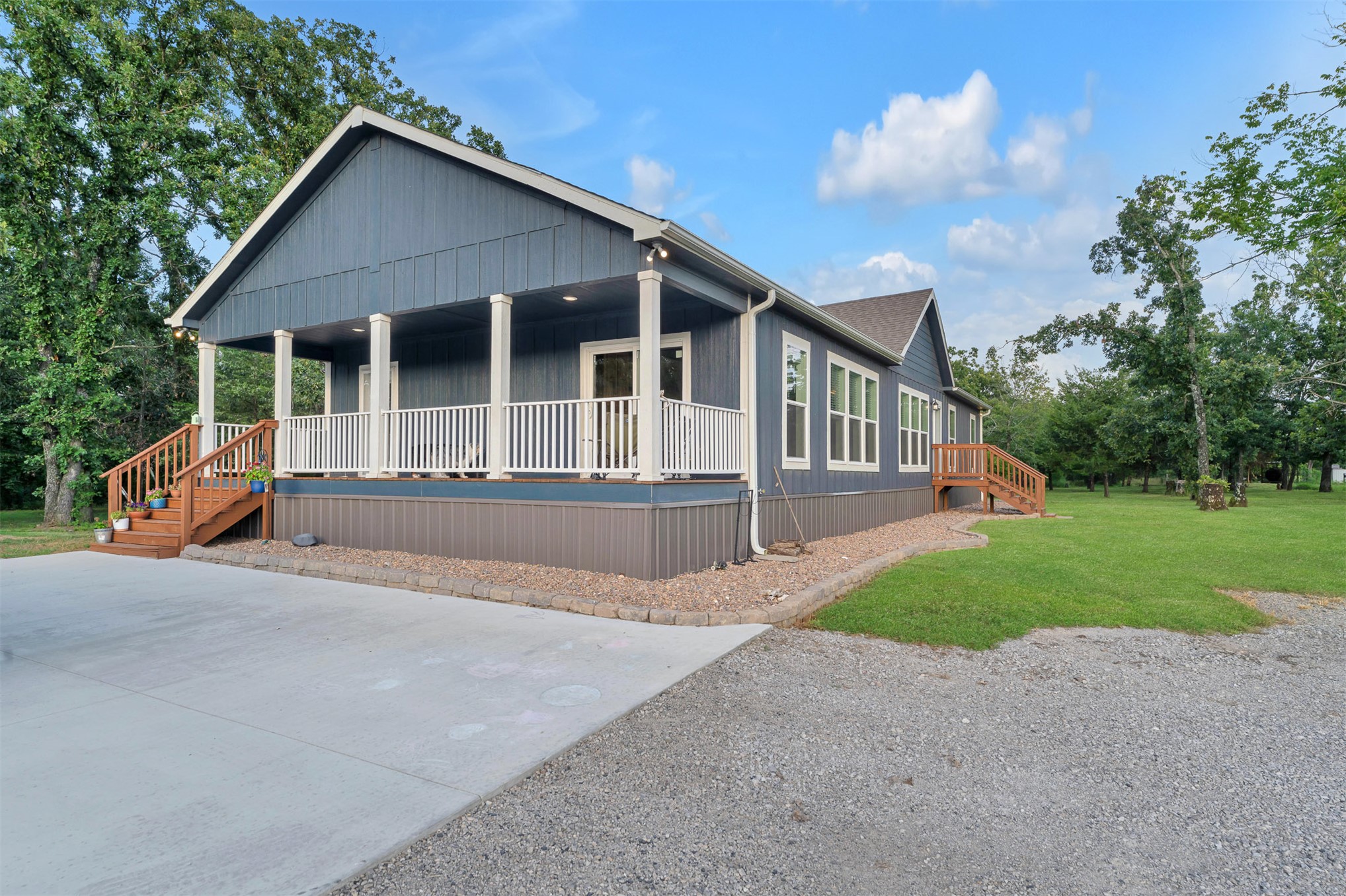 15291 East 400 Road Claremore, OK 74017 - Photo 15 of 96 Exterior featuring a covered porch with white columns, wood stairs, a white railing, and blue siding