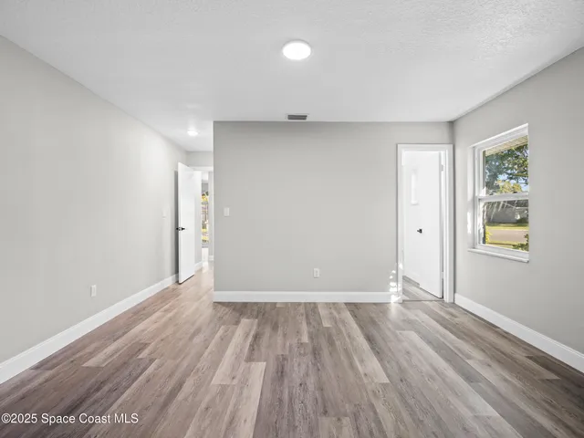 wooden floor in an empty room with a window