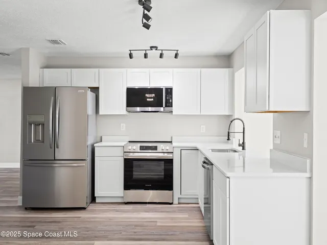 a kitchen with stainless steel appliances a refrigerator stove and sink