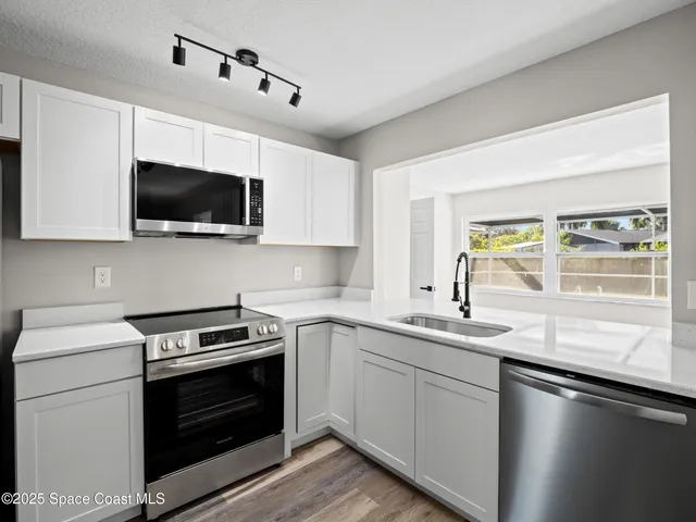a kitchen with a sink stove and microwave
