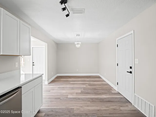 a view of an empty room with a kitchen