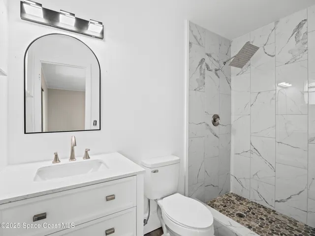 a bathroom with a sink a toilet and shower