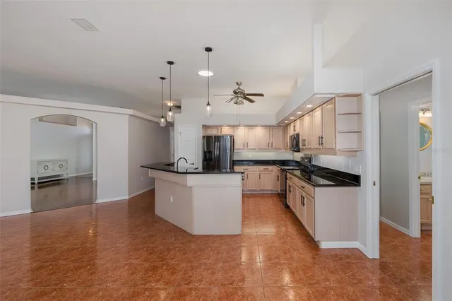 a kitchen with granite countertop a sink a counter top space stainless steel appliances and cabinets