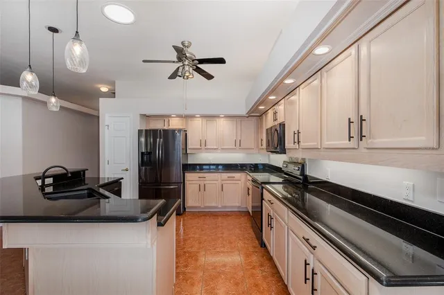 a kitchen with stainless steel appliances granite countertop a sink a stove and a wooden floor