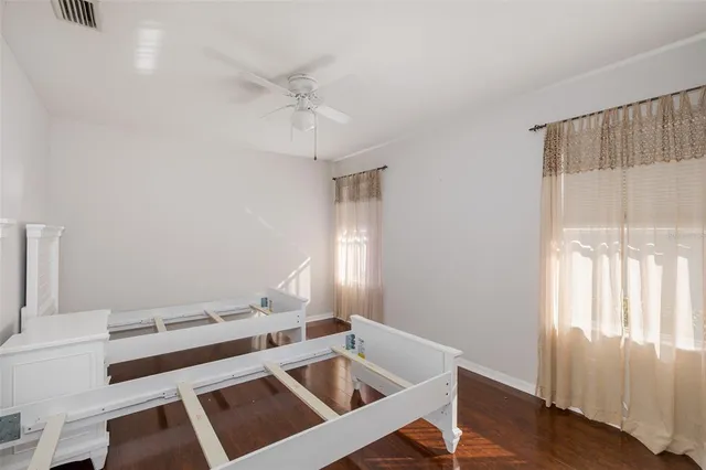 a view of an empty room with wooden floor and a fireplace