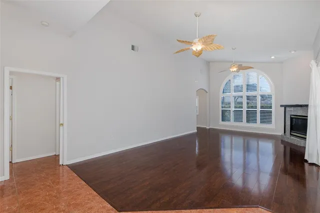 a view of wooden floor and a chandelier fan in a room