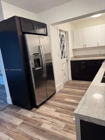a bedroom with a bed and a refrigerator