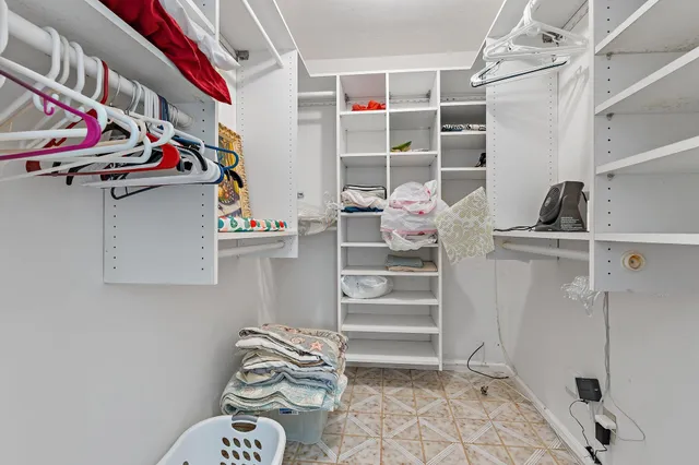 a view of walk in closet with clothes and shoes