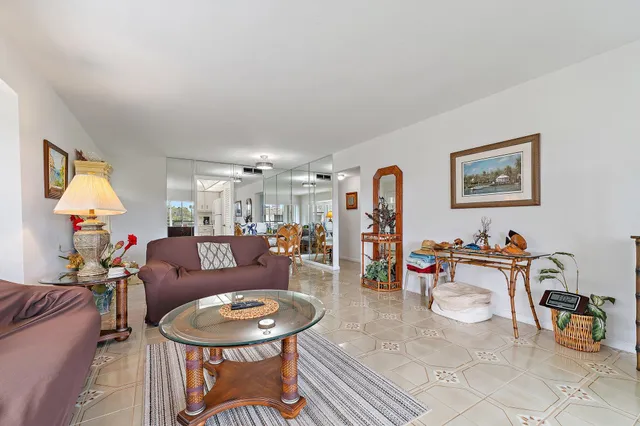a living room with furniture and a dining table with rug