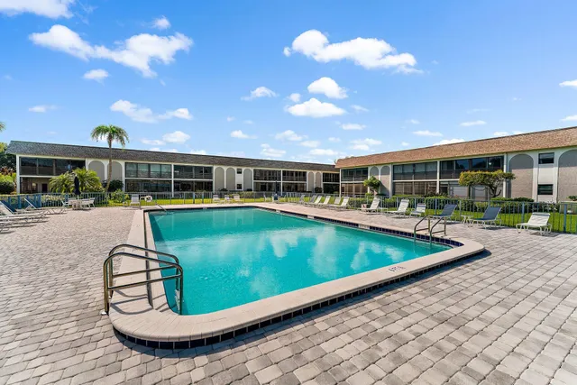 a view of a swimming pool with a patio and a yard