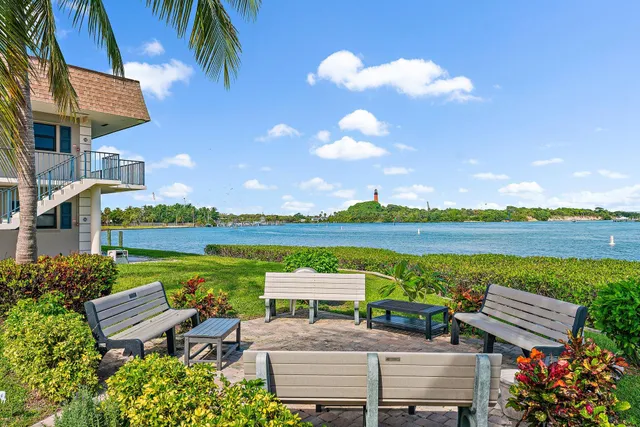 a view of a chairs and table in patio with a lake view
