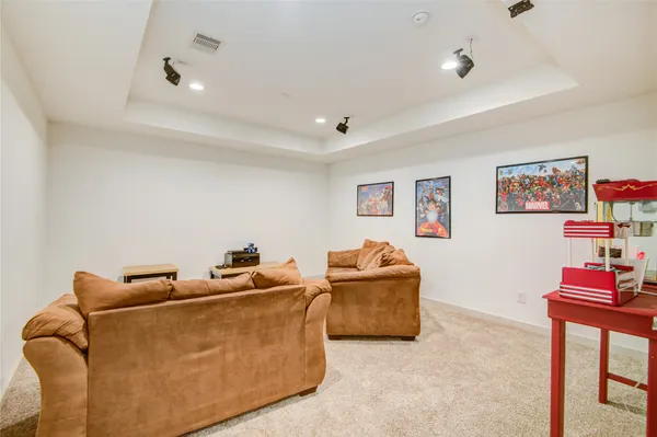 a spacious bedroom with a bed a chandelier and a couch