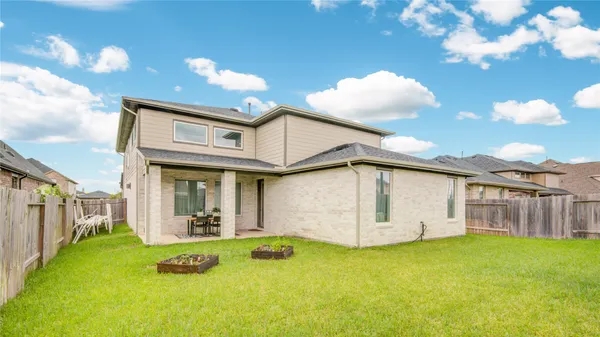 a front view of a house with a yard and potted plants