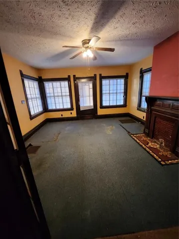 a view of an empty room with window and fireplace