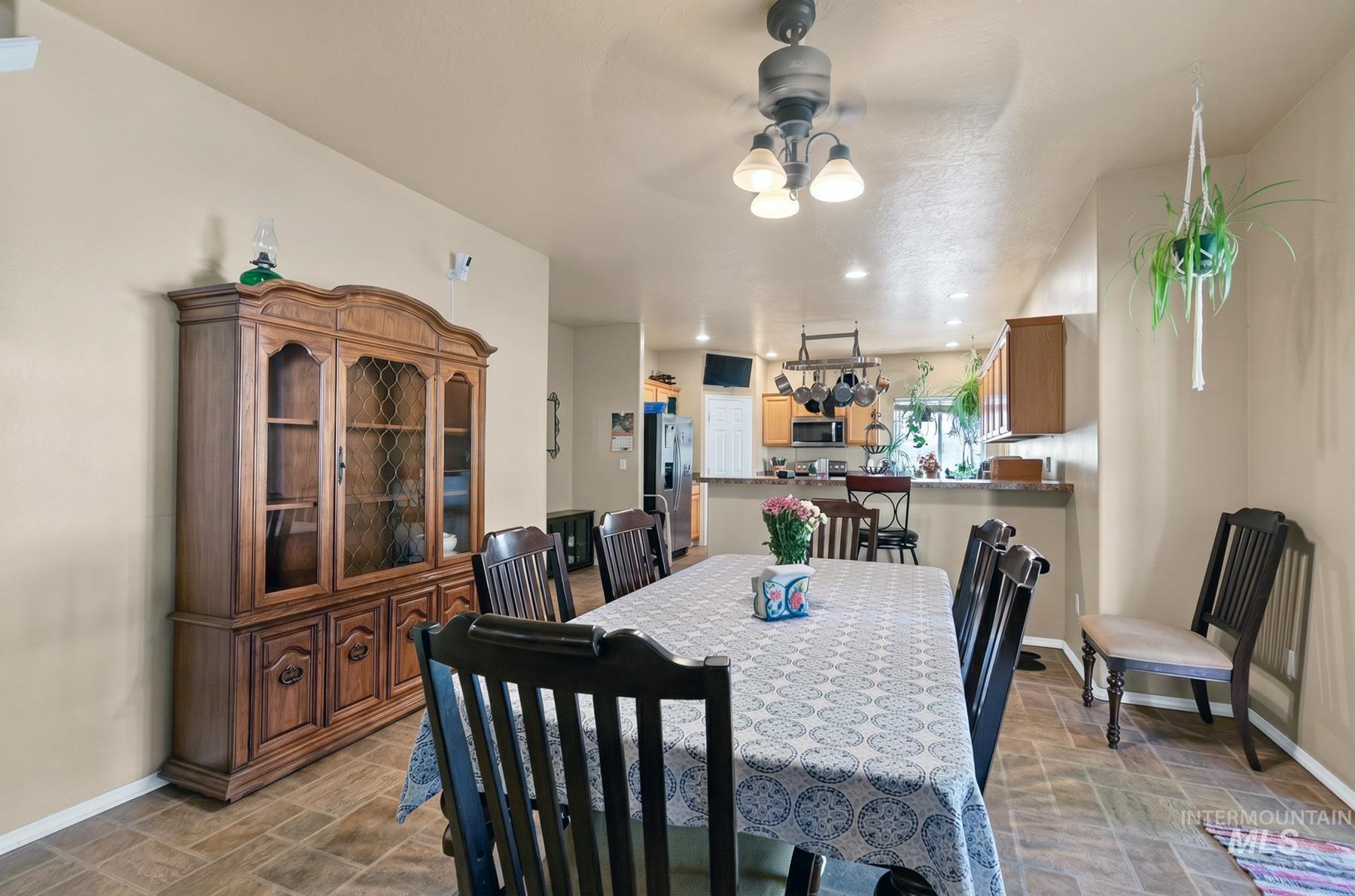 5020 Northrup Way Caldwell, ID 83607 - Photo 12 of 36 Spacious dining area featuring wood-finish flooring, a ceiling fan with integrated lighting, and neutral wall tones